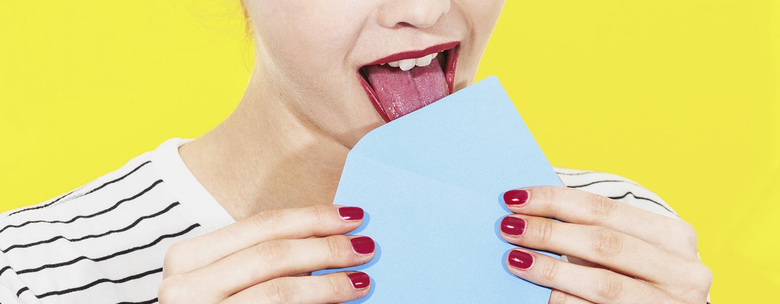 An image of a woman licking a letter envelope.
