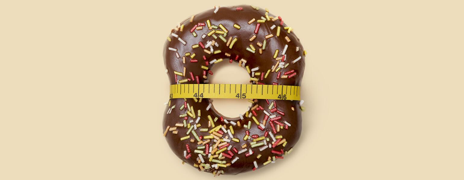 doughnut with measuring tape around it to represent losing weight after menopause