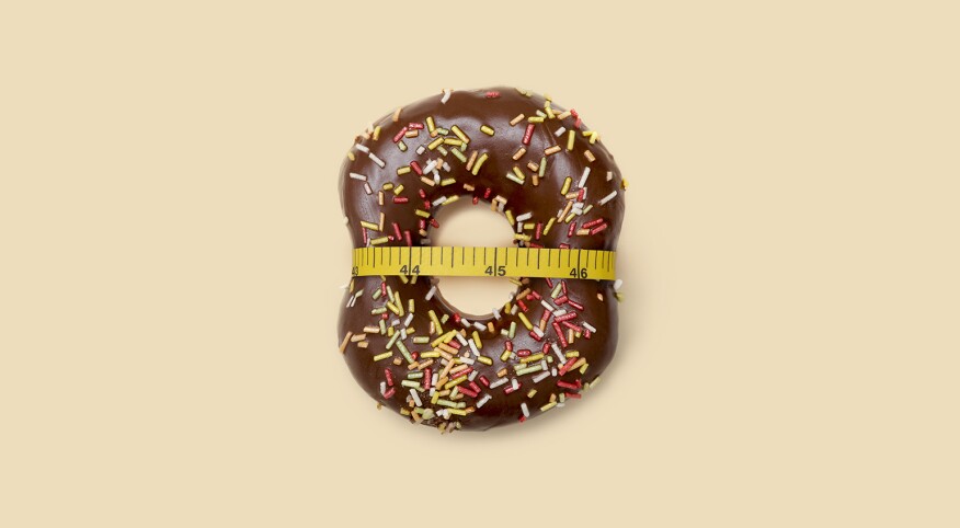 doughnut with measuring tape around it to represent losing weight after menopause