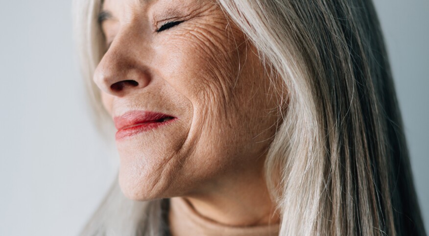 Woman, from side, smiling, with grey hair