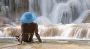 image of woman sitting in front of waterfall