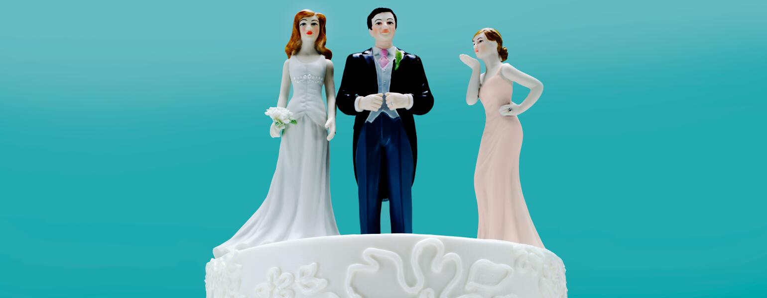 Wedding Cake with 3 toppers, a couple and a 2nd woman.