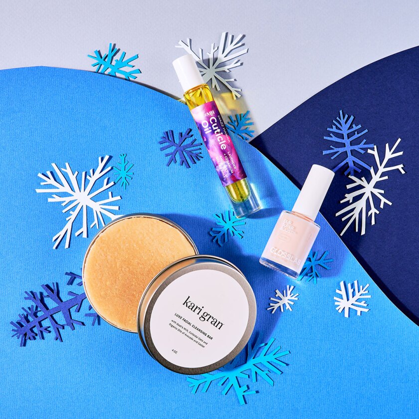 Beauty skincare products styled within cut paper winter scene