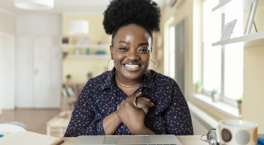 image_woman_sitting_facing_camera_smiling_GettyImages-1329381534_1800