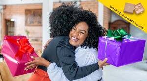 Two Black women friends exchanging gifts