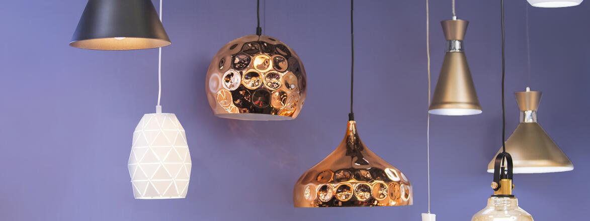 Variety of modern chandeliers on purple background.