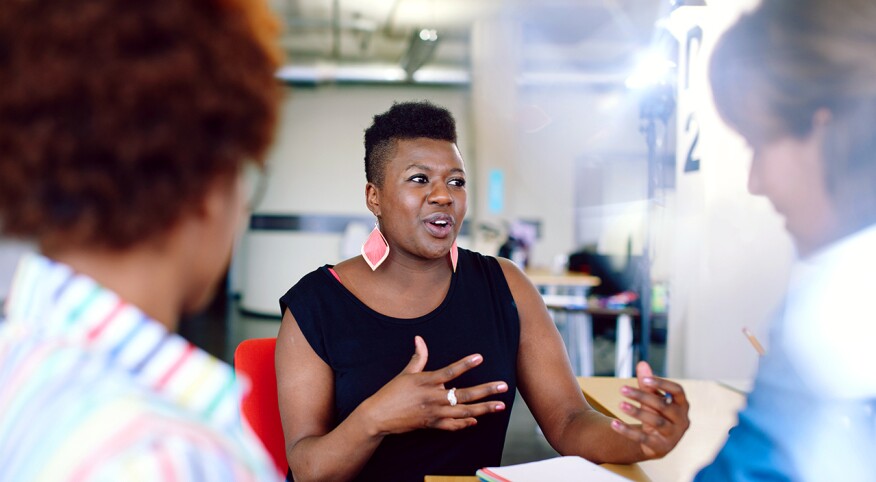 Woman speaking with other coworkers