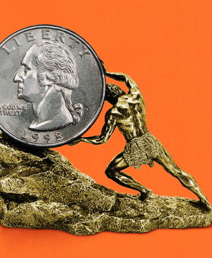 man pushing a larger coin up a rock