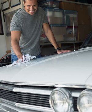 Man polishing white classic car
