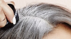 woman touching up her gray roots