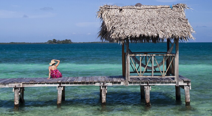 A dock over the crystal clear waters of the Caribbean in Belize.