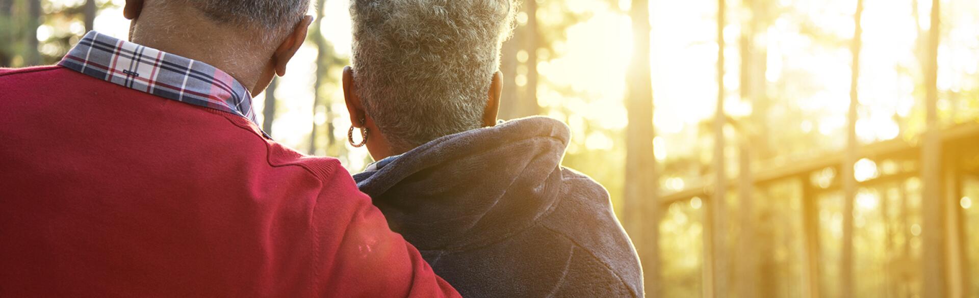 Active senior adult couple enjoy outdoor park at sunset.
