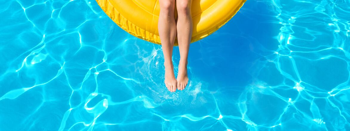 Woman floating on inflatable tube in pool on vacation in summer