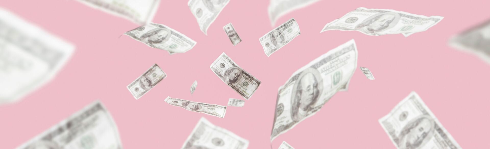 Money on a pink backdrop floating in the air