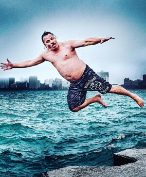 Shirtless man jumping into body of water