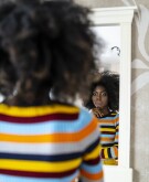 image_of_woman_looking_in_mirror_contemplative_GettyImages-1135286715_1800
