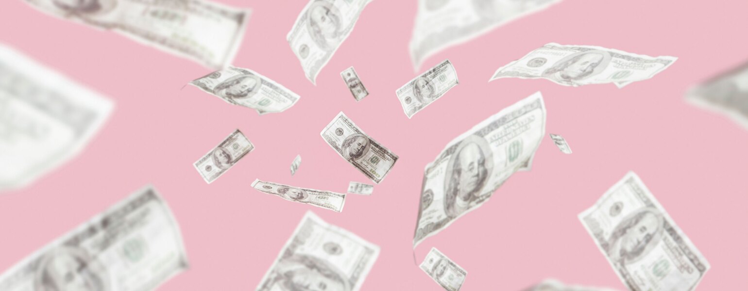 Money on a pink backdrop floating in the air