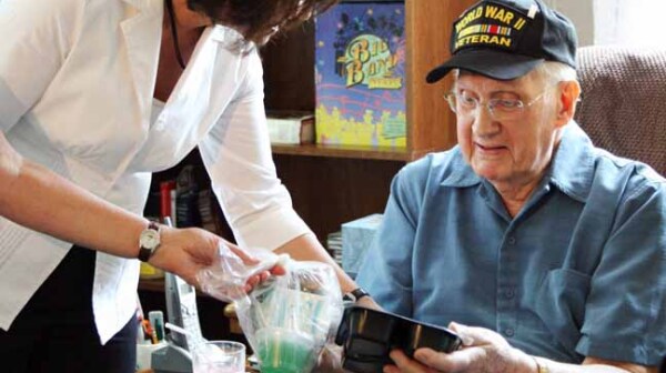 A Meals On Wheels volunteer serves a member of the greatest generation