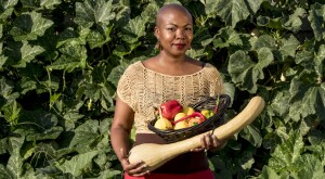 author towanna standing outside holding vegetables she grew in her garden