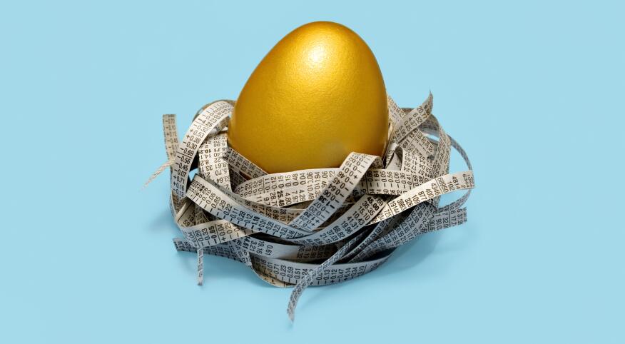 Golden egg in nest of strips of newspaper stock prices