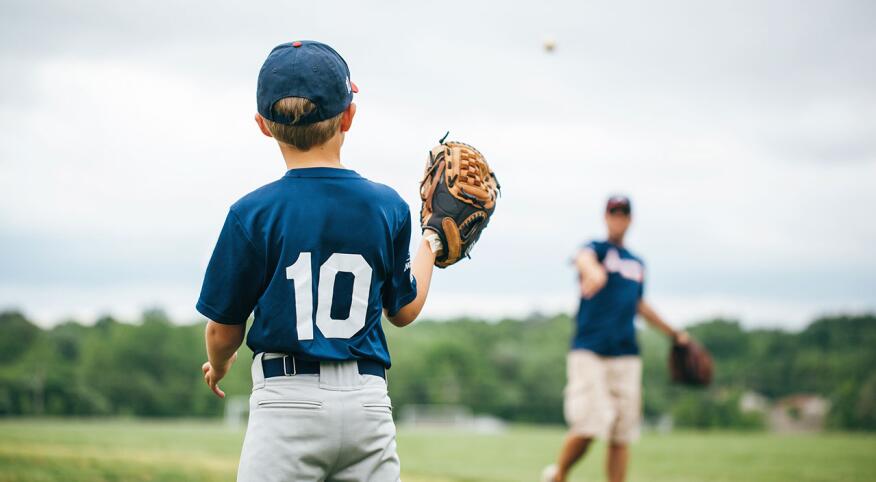 Child has baseball catch with father