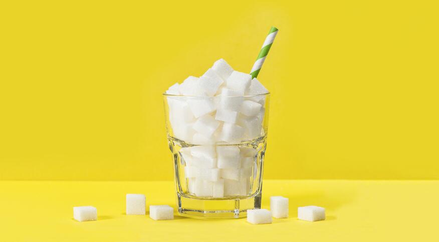 cup filled with sugar cubes with straw in it