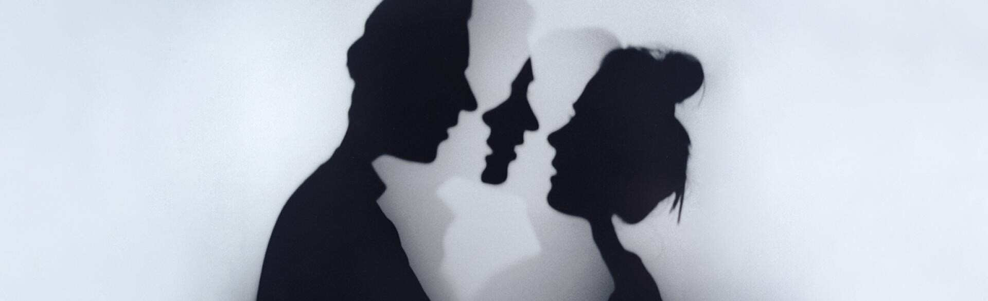 A photo of a woman and man standing face to face.
