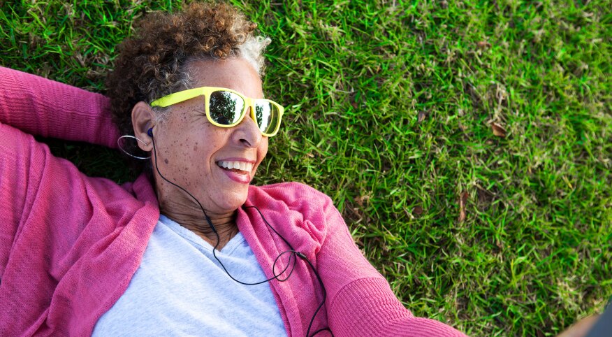 Woman lying on grass wearing sunglasses