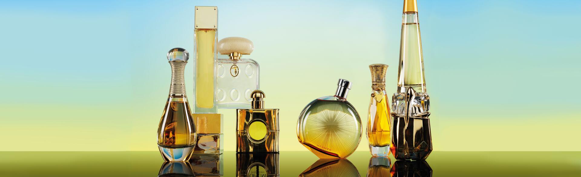 Seven Perfume bottles on a gradient blue to yellow background