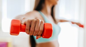 Woman exercising with her orange weights