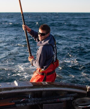 Man on a boat catching a tuna