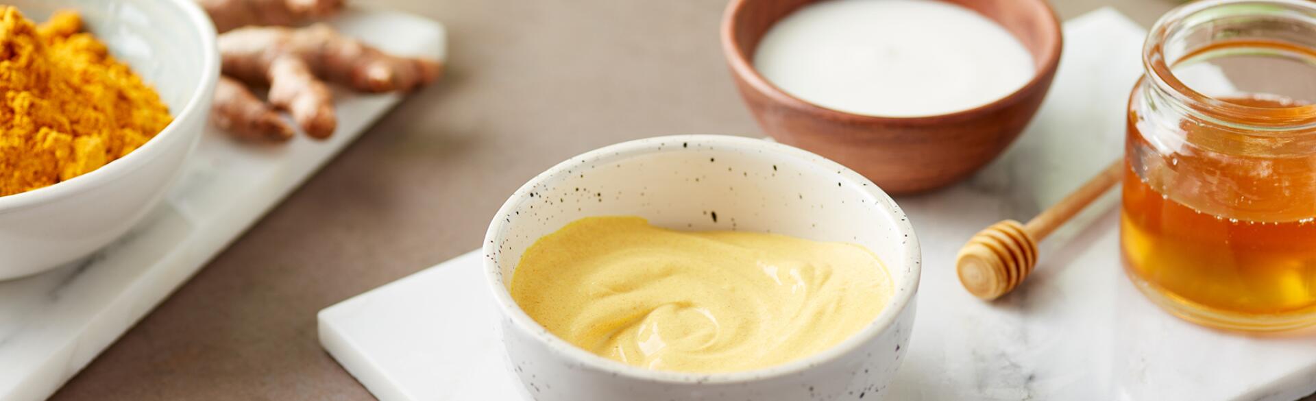 Still Life Of Homemade Organic Turmeric Mask On Marble Board with yogurt and honey.