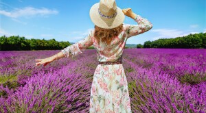 woman in sundress walking through flower field