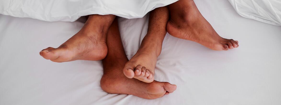 Cropped shot of an unrecognizable couple's feet while lying in bed together.