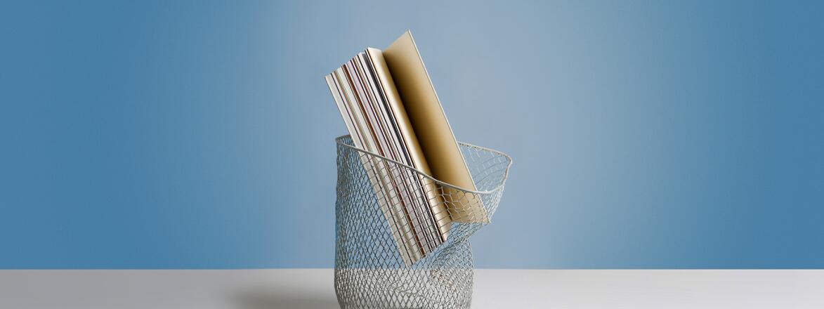 Large book in wastepaper basket