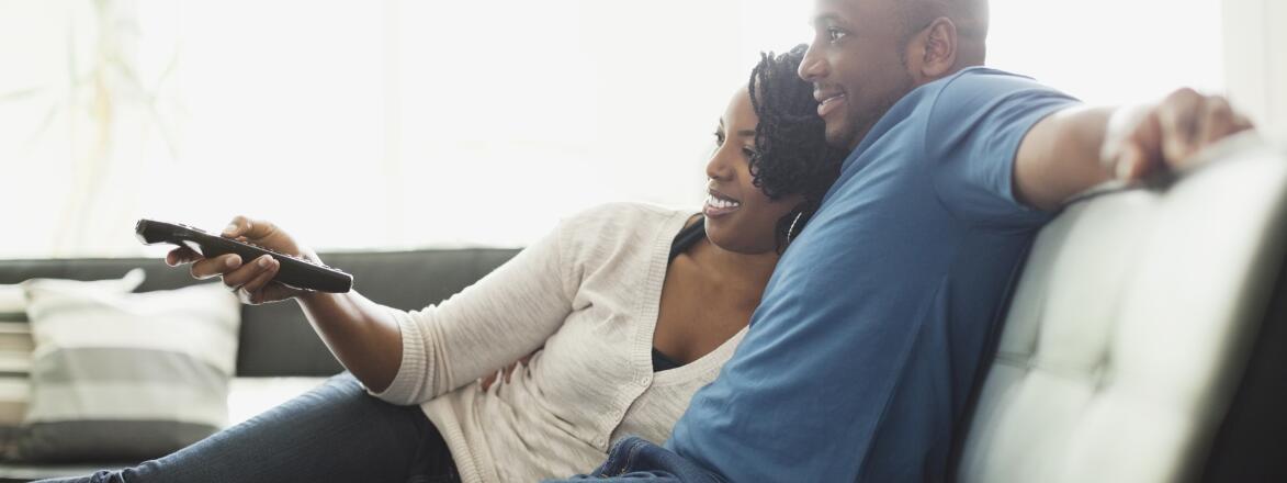 couple sitting on couch watching tv