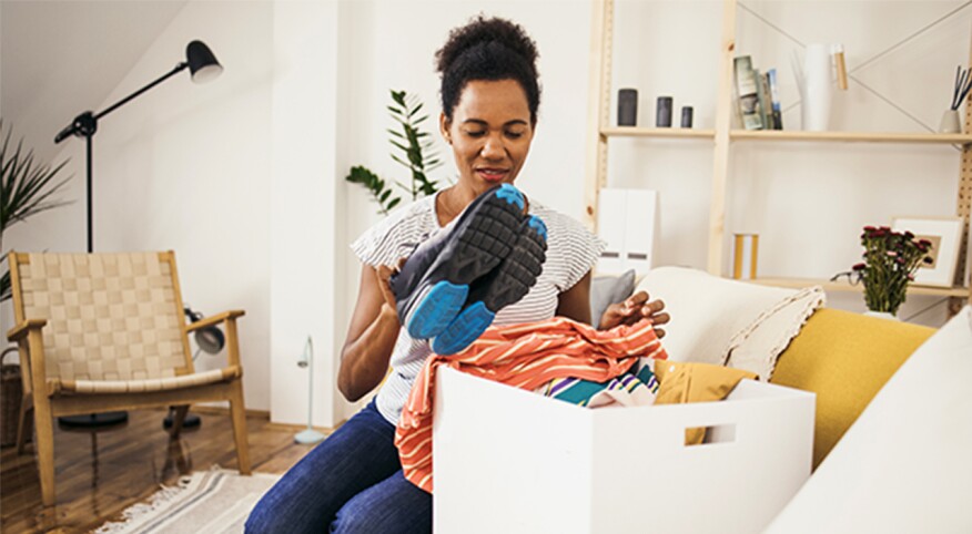 Black woman in her 40s clearing her space of clutter