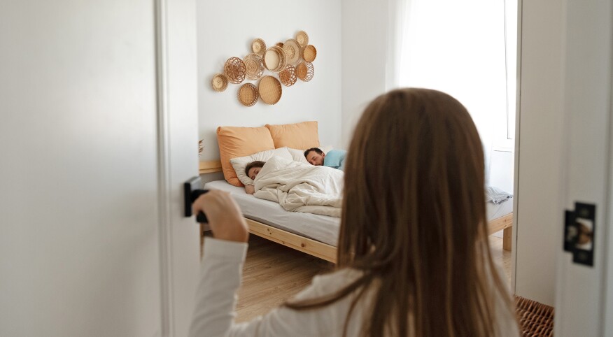 Child looking into parents bedroom while they're sleeping