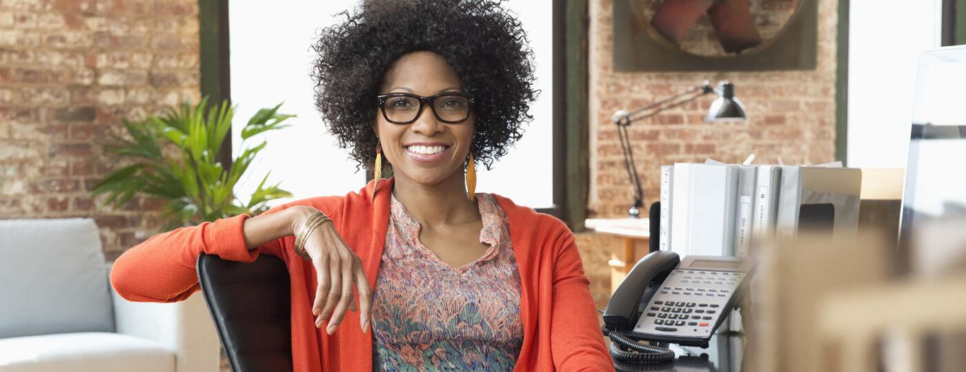 image_of_woman_smiling_sitting_in_office_GettyImages-672159651_1800