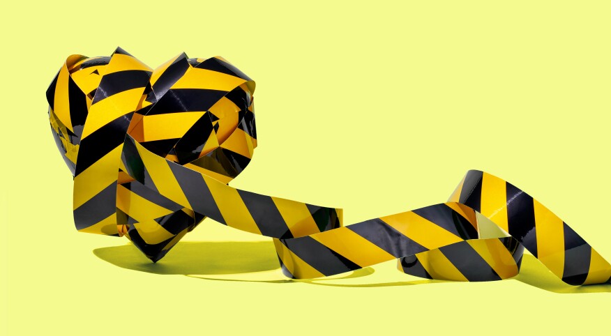 Black and yellow caution tape shaped into a heart