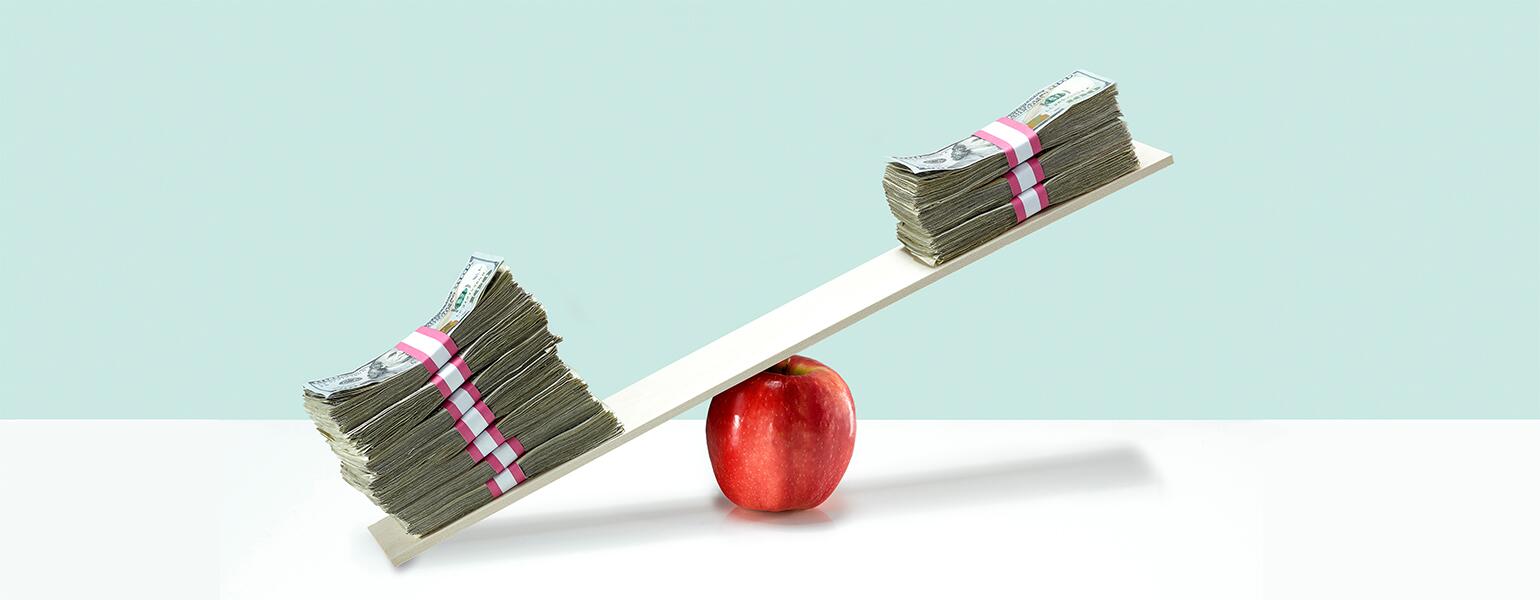 image of money on balance scale on top of apple