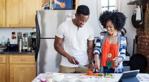 Image of couple cutting food in the kitchen