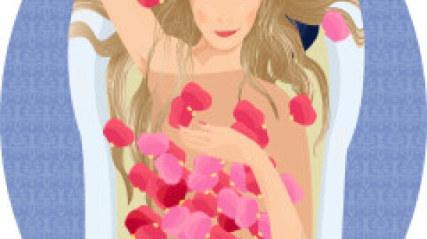 Blonde woman taking a bath with rose petals
