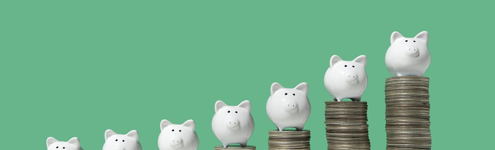 Little piggy banks on ascending stacks of coins