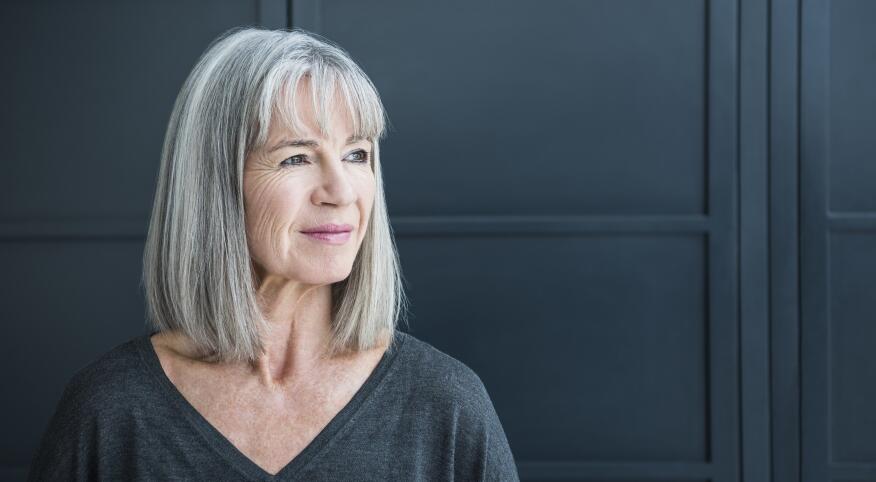 woman with gray hair looking off to camera