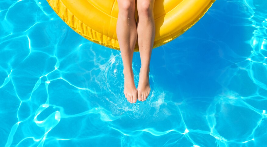 Woman floating on inflatable tube in pool on vacation in summer