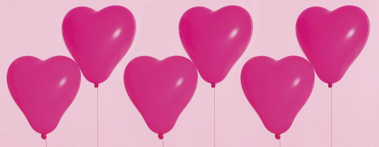 six pink heart balloons floating