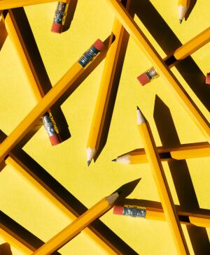 Layers Of Pencils Scattered On yellow Paper