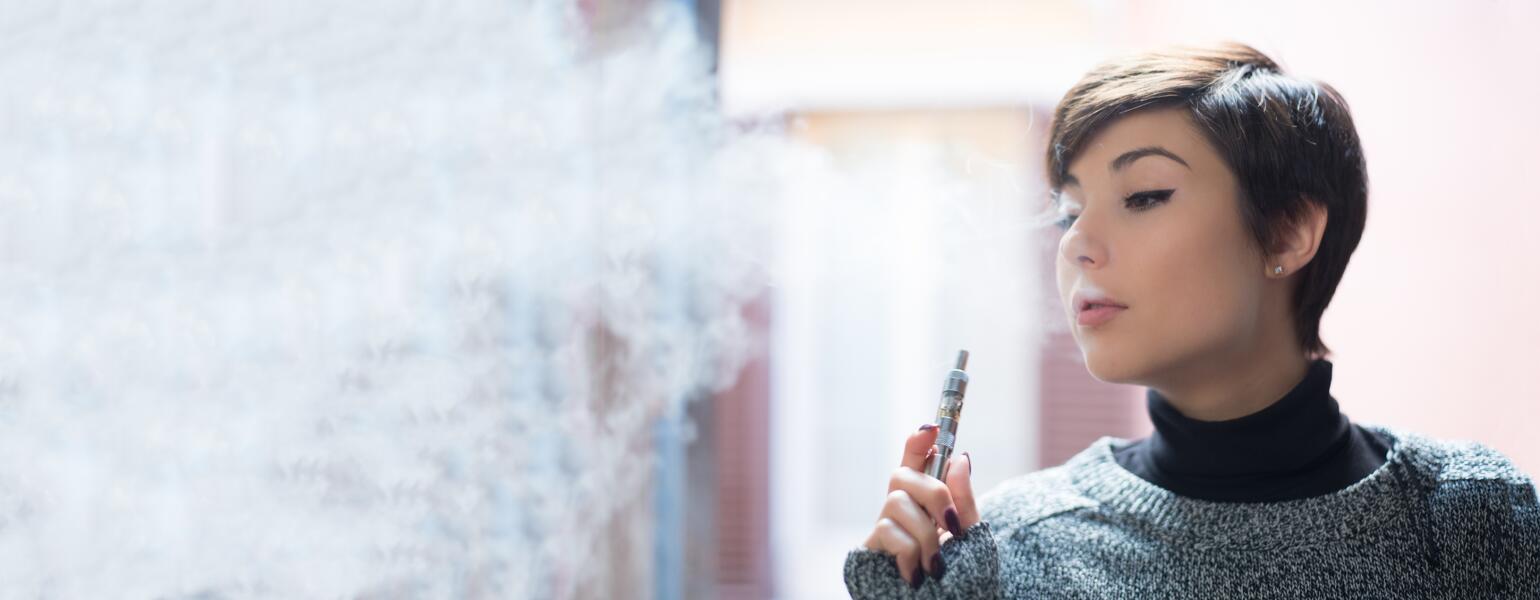 close up of a young woman smoking a vape pen
