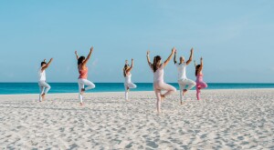 Women on a beach doing yoga at Bucuti & Tara in Aruba